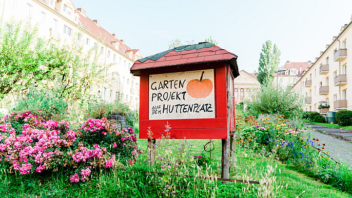 Huttenplatz in the front west The picture shows the sign for a garden project in the front west.